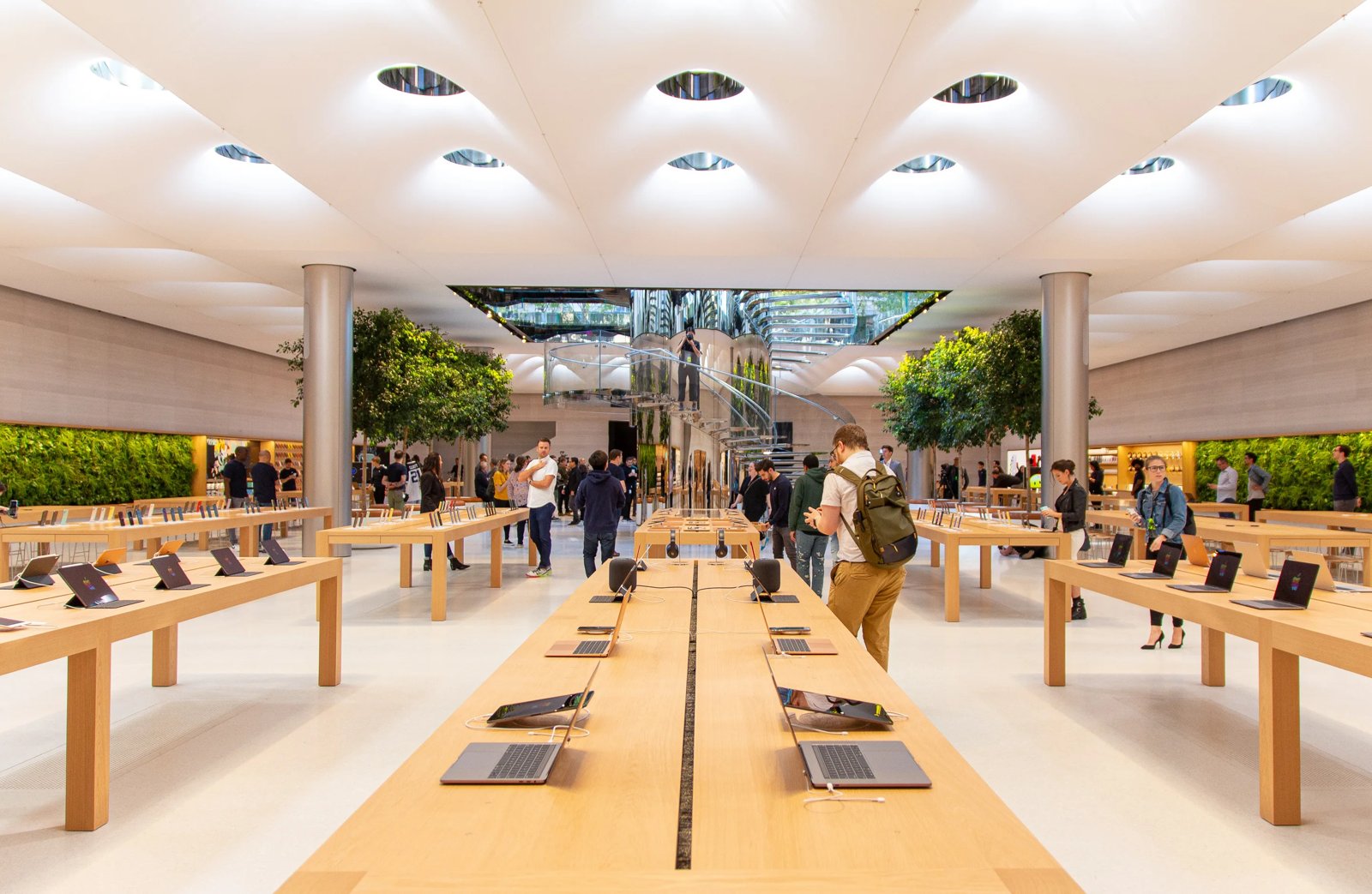 Apple store interior in New York City with illuminated ceiling, display tables and trees