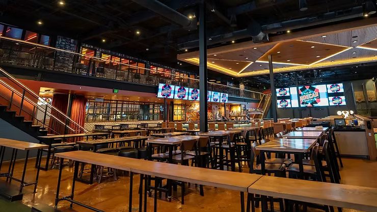 Restaurant and sports bar with rows of video screens above the dining area