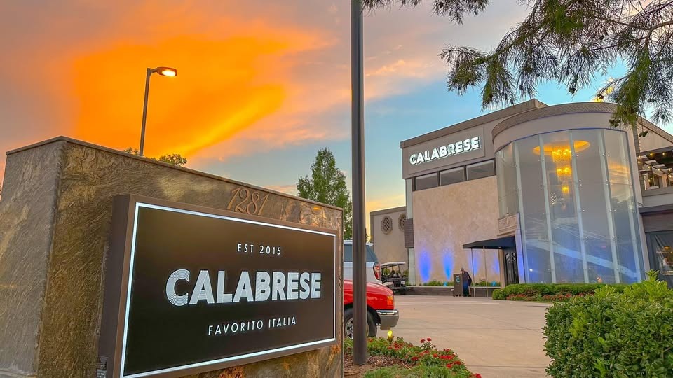 Calabrese restaurant sign and glass-front entrance at sunset in Southlake