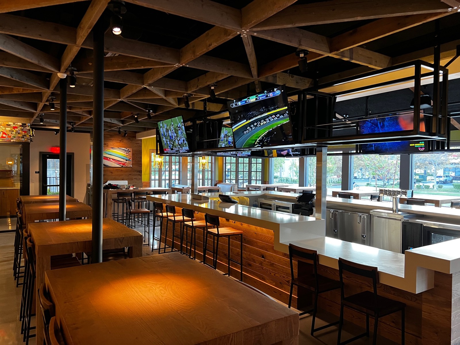 California Pizza Kitchen bar with ceiling-mounted TVs over a white counter and wood paneling