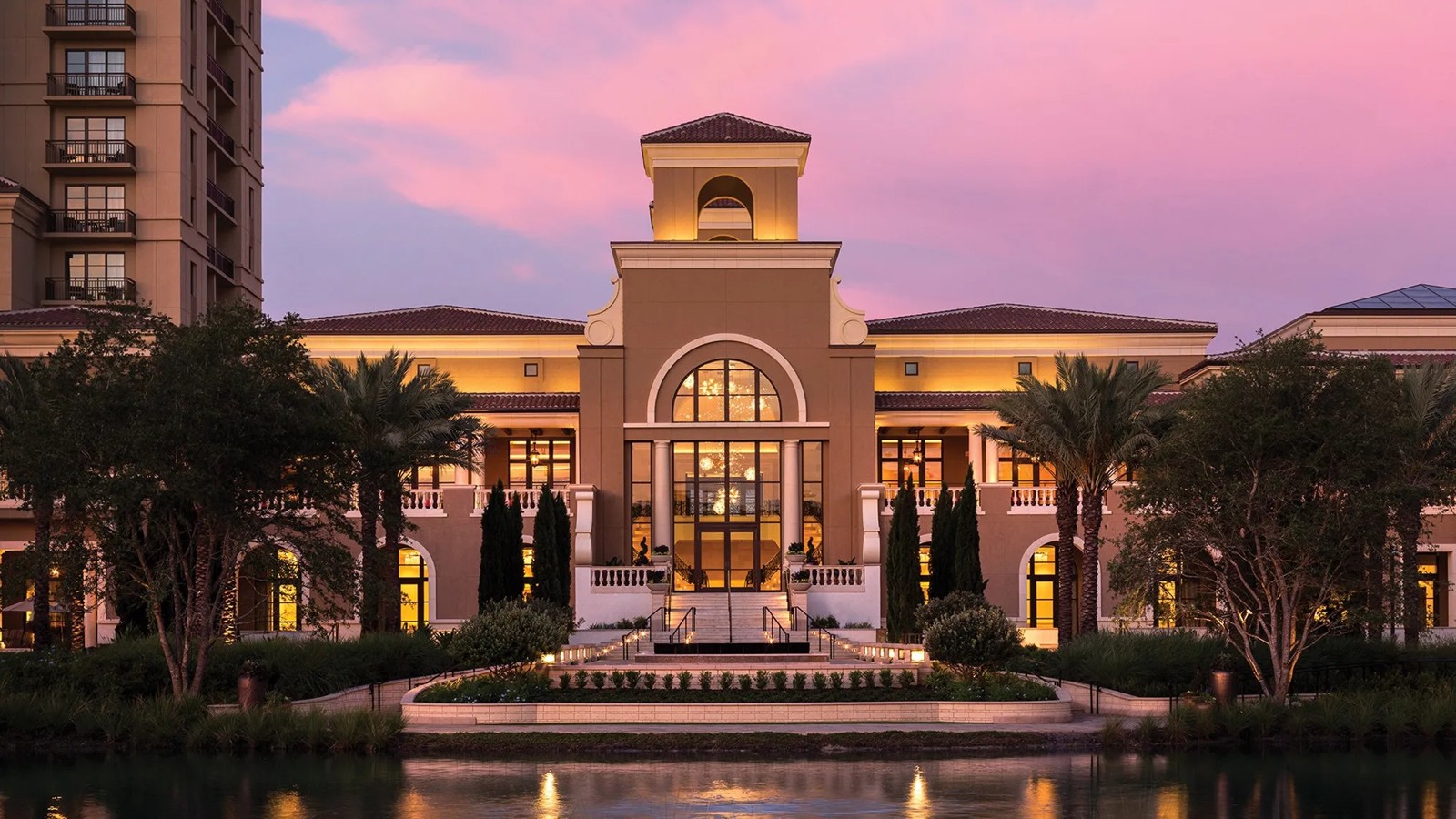 Four Seasons Walt Disney World resort entrance glowing at sunset beside the lake