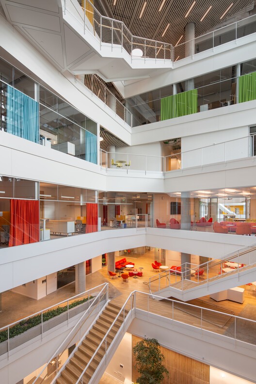 Multi-story atrium with open floors, stairs and colorful lounge areas