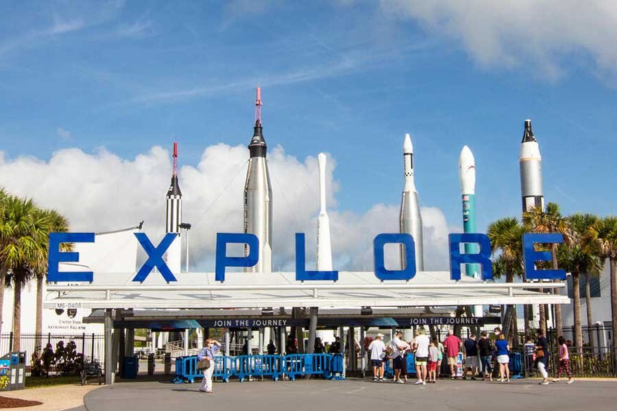 Kennedy Space Center visitor entrance with the EXPLORE sign and rockets standing behind it