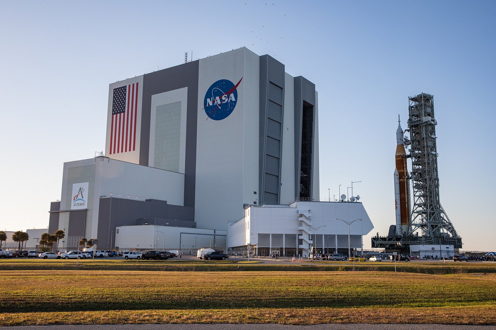 Vehicle Assembly Building at Kennedy Space Center with the NASA logo, American flag and a rocket on its launch tower