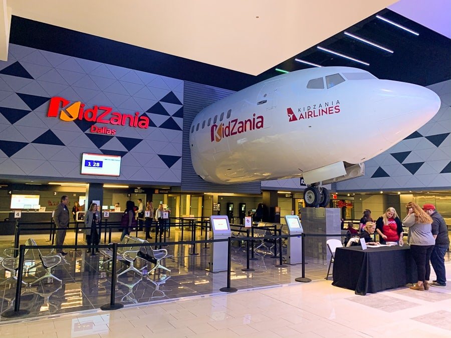 KidZania Dallas entrance with a KidZania Airlines airplane above the check-in area
