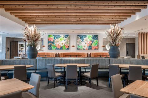 Mi Cocina dining room with banquette seating, wood slat ceiling and colorful floral artwork