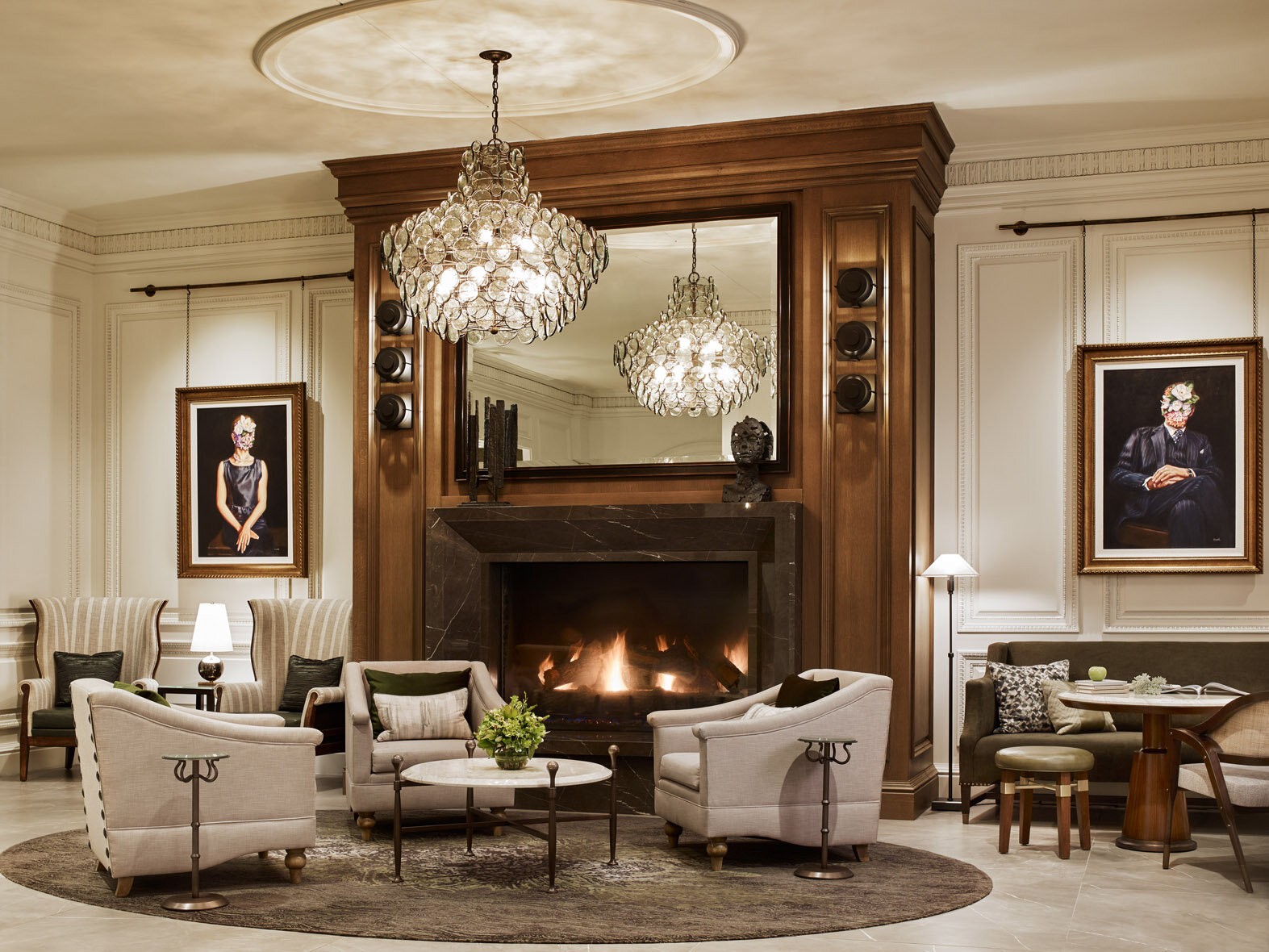 The Whitley lobby lounge with fireplace, crystal chandeliers and framed portraits