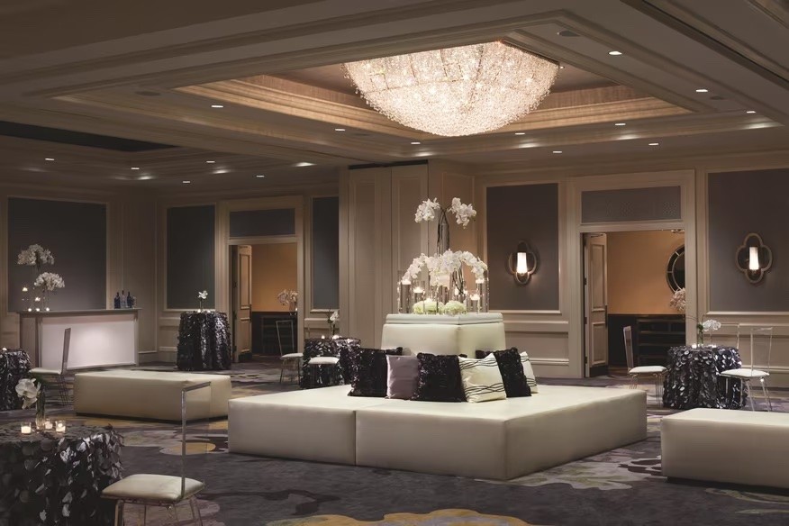 The Whitley event space with a crystal chandelier, white seating and floral arrangements